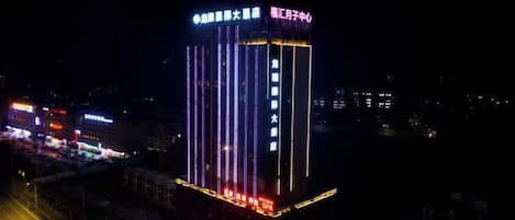 A tall hotel building with illuminated signage and vertical light strips.