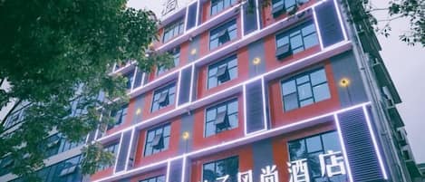 A multi-story hotel building with illuminated signage and windows.