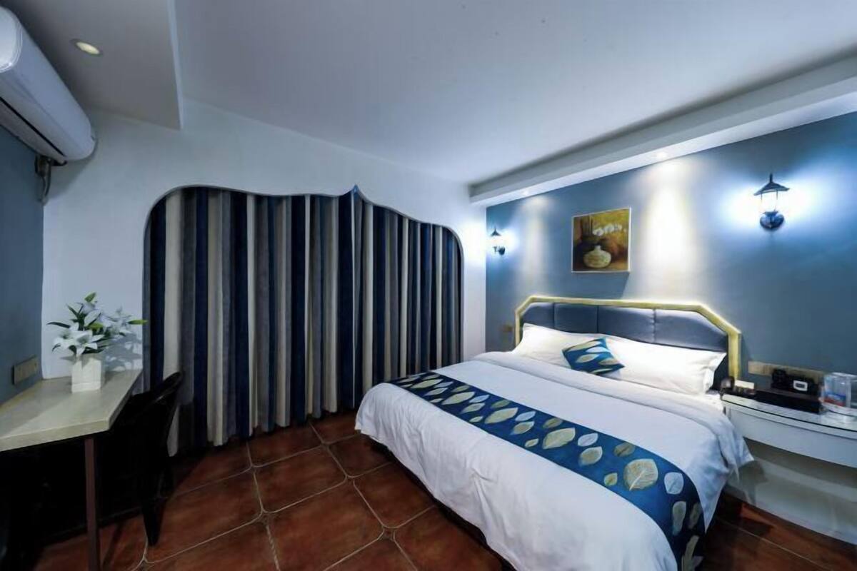 Una habitación de hotel con una cama, un escritorio y una silla.