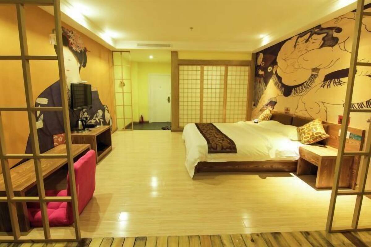 A traditional Japanese-style bedroom with tatami flooring, a low wooden bed, and a sliding door.