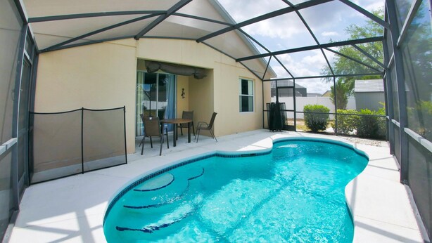 A swimming pool with a covered patio area. - 5/4 Pool Home Located in Sunset Ridge Community! (Davenport)