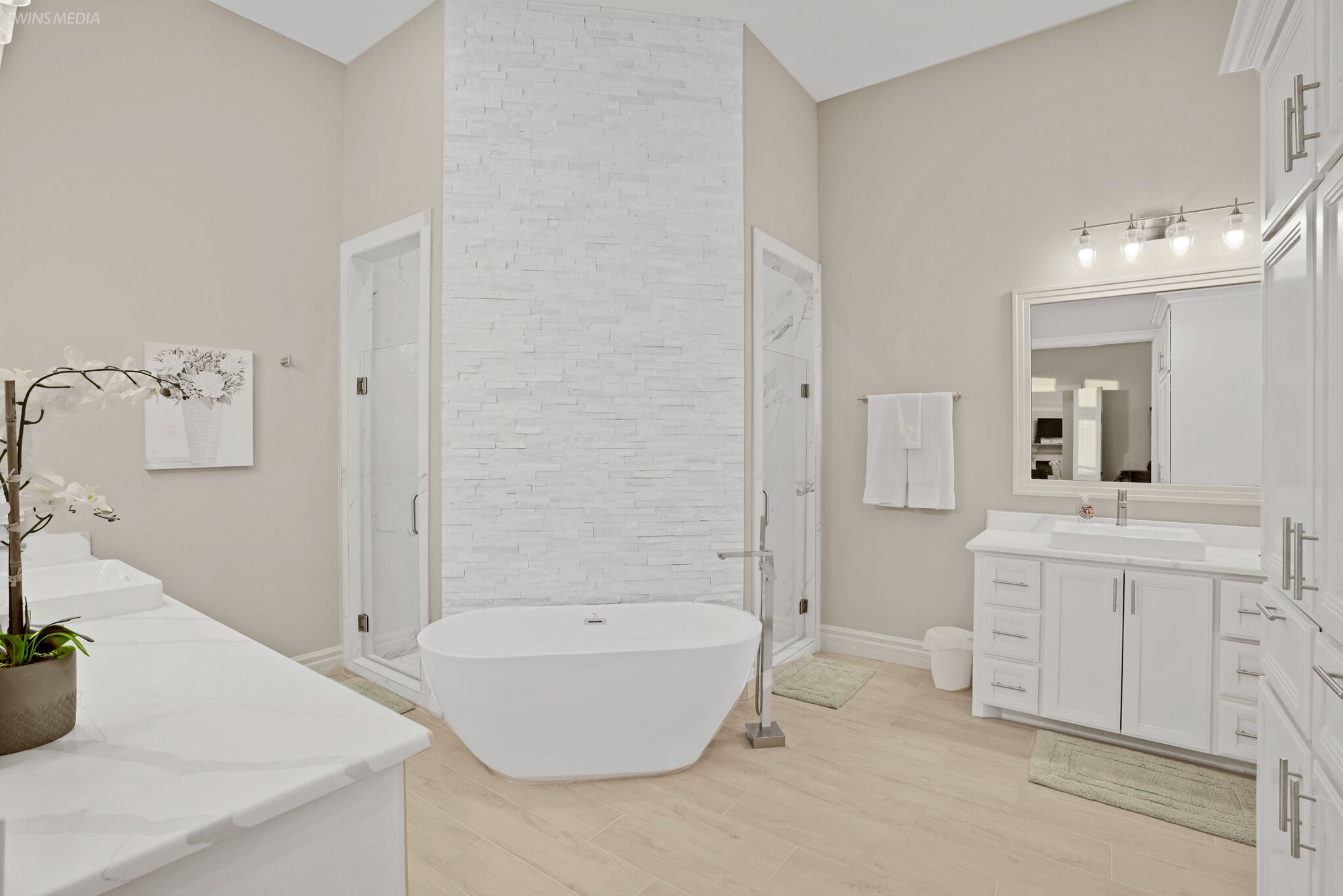 Une salle de bain moderne avec une baignoire sur pieds, un grand miroir et un meuble-lavabo blanc.