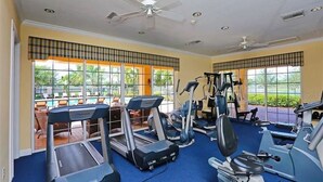 Une salle de sport équipée de tapis de course, de vélos elliptiques et de poids libres.