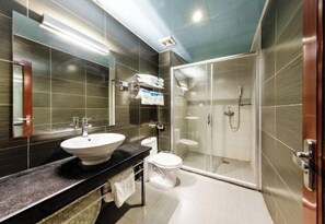 Ein modernes Badezimmer mit großem Spiegel, Waschbecken, Toilette und einer Duschkabine.