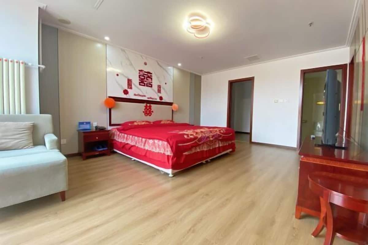 A bedroom with a bed, bedside table, and a desk.