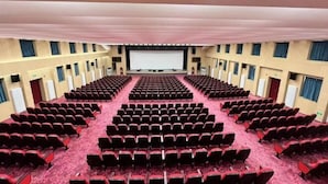 A large auditorium with rows of red chairs and a central stage. - Hancun River Villa (Beijing)
