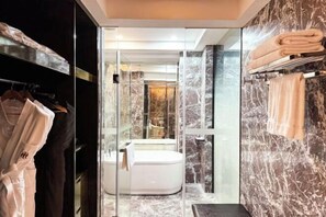 A modern bathroom with a glass-enclosed shower, marble walls, and a white bathtub. - Nature Hotel Four Seasons (Quanzhou)