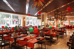 A restaurant with multiple tables, red and green balloons, and a modern ceiling design. - Nature Hotel Four Seasons (Quanzhou)