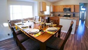 A dining area with a wooden table set for six, surrounded by cushioned chairs. - Beautiful 5/5 Bedroom Home!!! (Davenport)