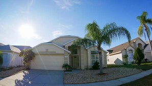 A residential house with a driveway, a small front yard, and a palm tree. - Beautiful 5/5 Bedroom Home!!! (Davenport)