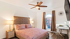 A bedroom with a bed, bedside tables, a desk, and a ceiling fan. - Near Highways, Family Friendly, Garage, Foosball, Grill, Dart, Tesla Charger (Plano)