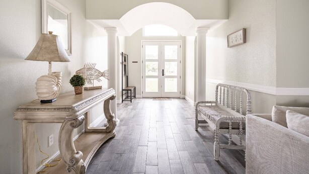 A hallway with a white console table, a lamp, a small plant, and a bench. - Casa Azul Tampa - 5BR Waterfront Villa w/ Pool (Tampa)