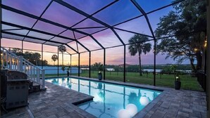 A swimming pool with a covered patio area, a barbecue grill, and a view of the surrounding landscape. - Casa Azul Tampa - 5BR Waterfront Villa w/ Pool (Tampa)