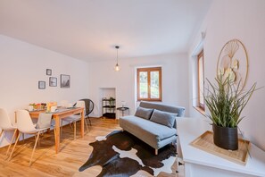 A modern living room with a wooden dining table, grey sofa, and a cowhide rug. - Casa Elvezia, Piandera (Lugano), Switzerland (Piandera (Lugano))