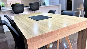 Un espace repas moderne avec une table en bois et des chaises noires.