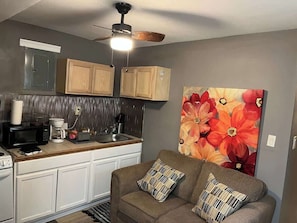 A compact kitchen with a microwave, coffee maker, and cabinets.