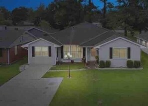 A two-story house with a front porch, a driveway, and a well-maintained lawn.