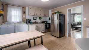 Eine kleine Küche mit Kühlschrank, Waschmaschine und Essecke.