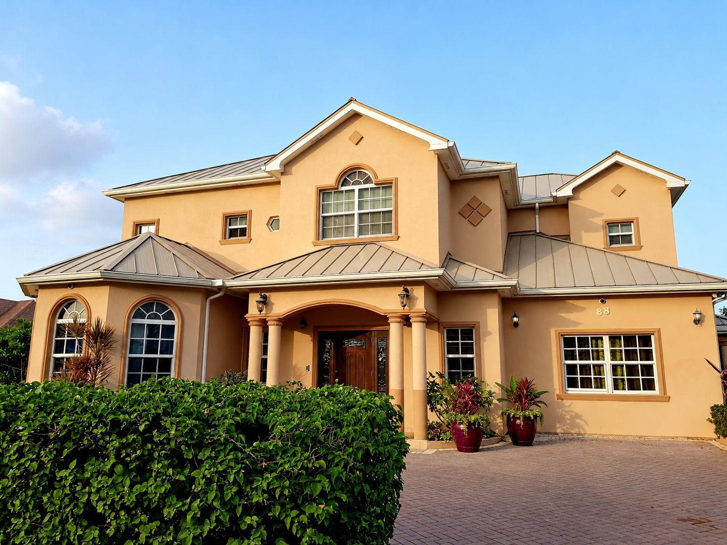 A two-story house with a symmetrical facade, a central entrance with columns, and a number '88' on the right side.