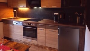 A modern kitchen with wooden cabinets, stainless steel appliances, and a built-in oven.