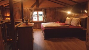 A cozy room with a bed, a desk, and a window.