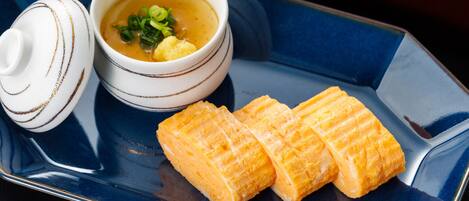 A blue tray with a bowl of soup and a small container.