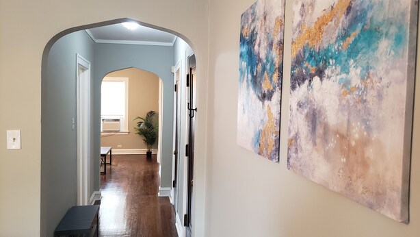 A hallway with a wooden floor, a bench, and two abstract paintings on the wall. - Comfy Bed/Free Parking&Wifi /NearHosp/ORD/MDW/DT (Berwyn)