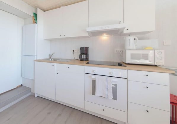Kitchen features an oven, coffee maker, and microwave.
