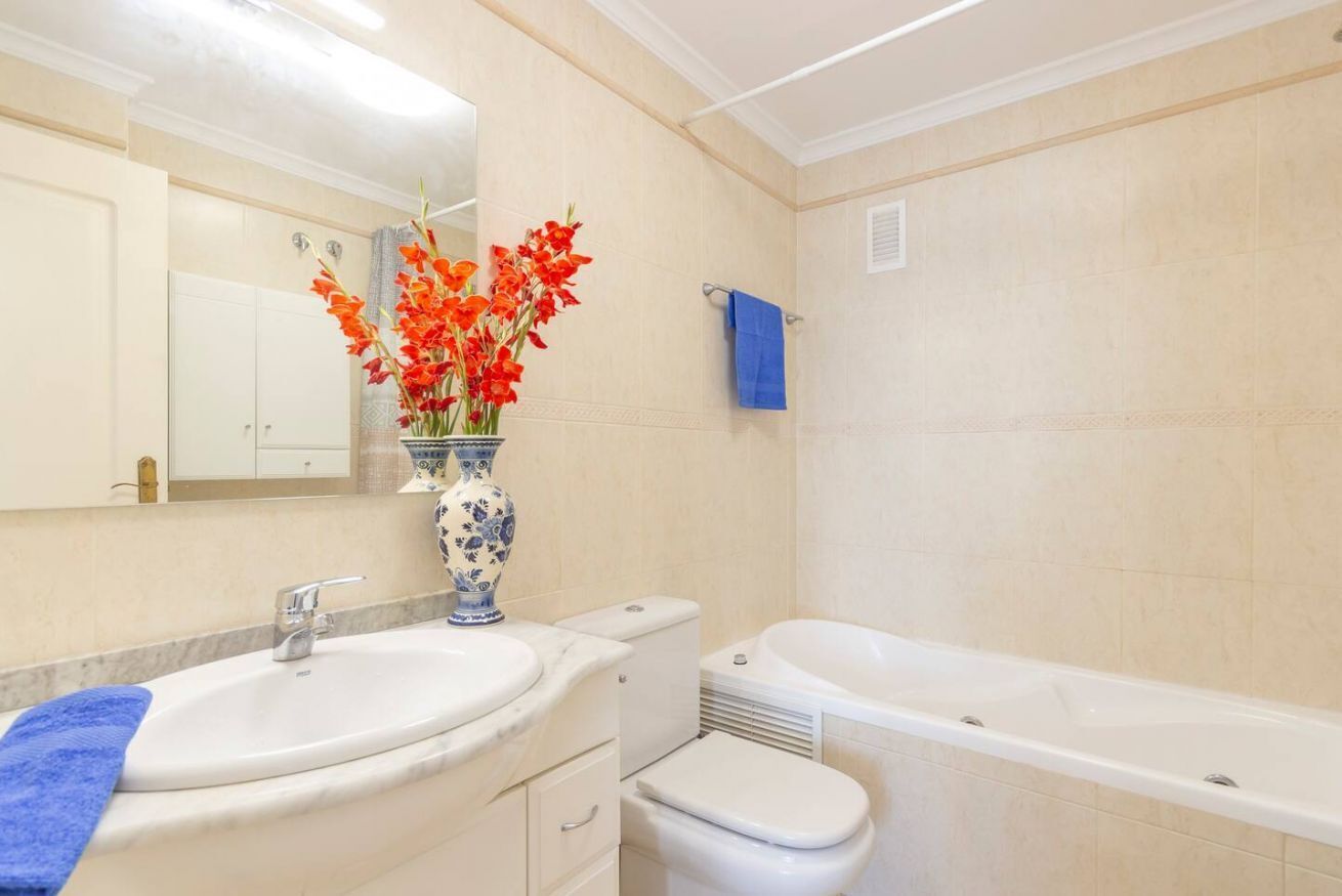Ein Badezimmer mit Waschbecken, Toilette, Badewanne und Spiegel.