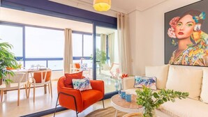 Un soggiorno moderno con un divano, un tavolo da pranzo con sedie, un tavolino da caffè e un'ampia finestra vista all'esterno.