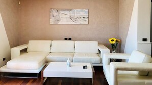 Ein modernes Wohnzimmer mit einer Eckcouch, einem Couchtisch und einem Gemälde an der Wand.