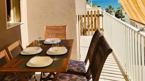 Ein Balkon mit Tisch für zwei Personen, Stühlen und Meerblick.
