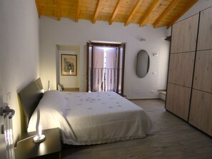 Cozy retreat with a bed, bedside table, and wardrobe, offering a peaceful view from the window.