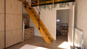 A room with a wooden staircase, a bookshelf, and a radiator. - Escape To Umbria, Little Alley (Porchiano del Monte)