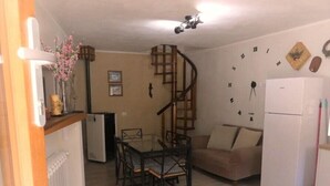 A compact kitchen with a dining area, a spiral staircase, and a refrigerator. - Escape To Umbria, Little Alley (Porchiano del Monte)