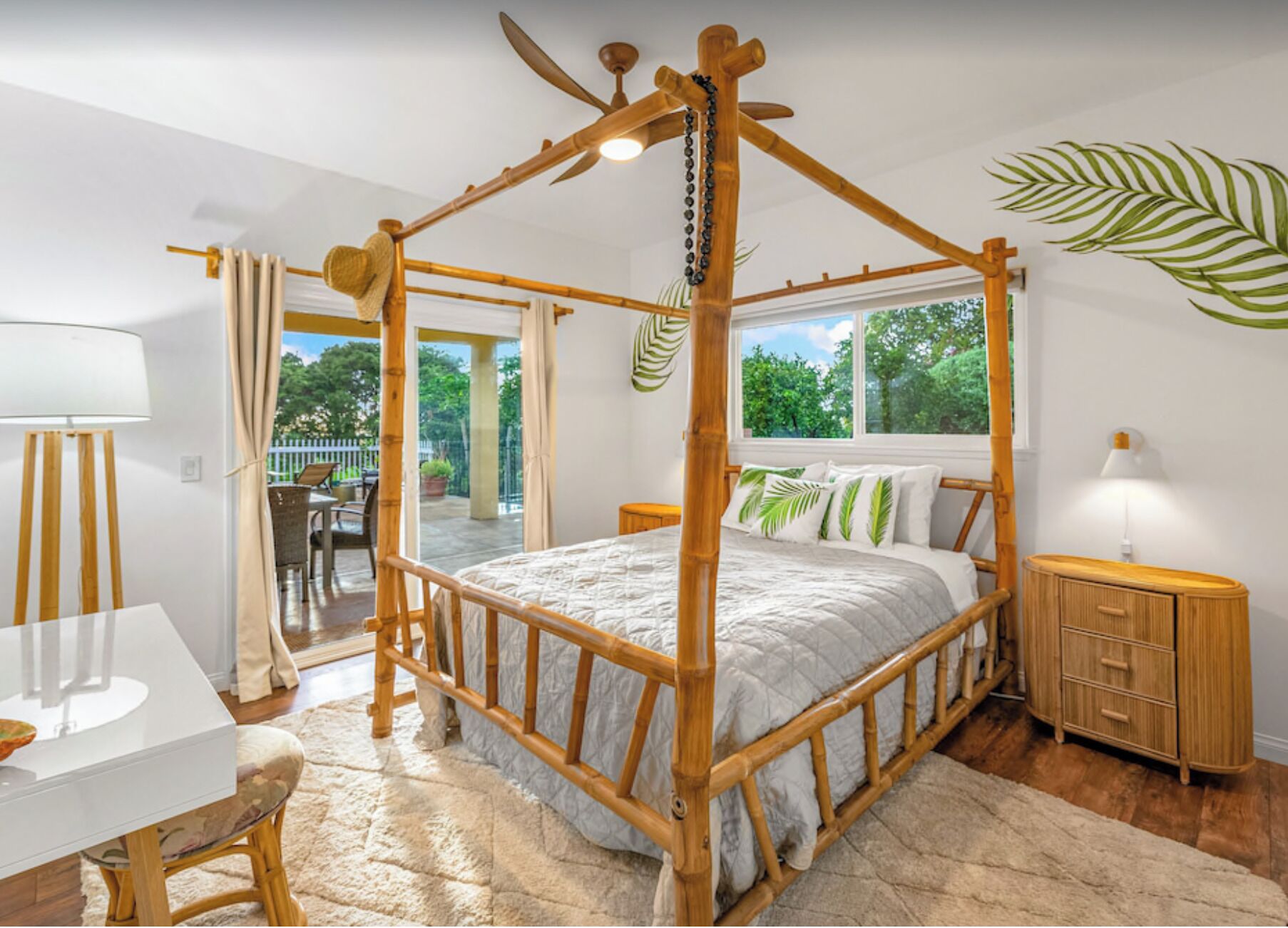 A room with a four-poster bed, a dining table, and a view of the outdoors.