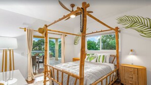 A room with a four-poster bed, a dining table, and a view of the outdoors. - Paradise Found (Waikoloa Village)