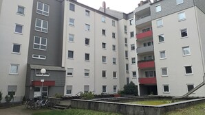 A multi-story residential building with a flat facade, balconies, and a small courtyard with bicycles. - Carpe Diem Frankenthal Palatinate Wine Route Kurpfalz (Frankenthal)