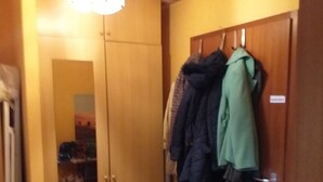 A room with a wooden wardrobe, a mirror, and a coat rack with several coats. - Carpe Diem Frankenthal Palatinate Wine Route Kurpfalz (Frankenthal)