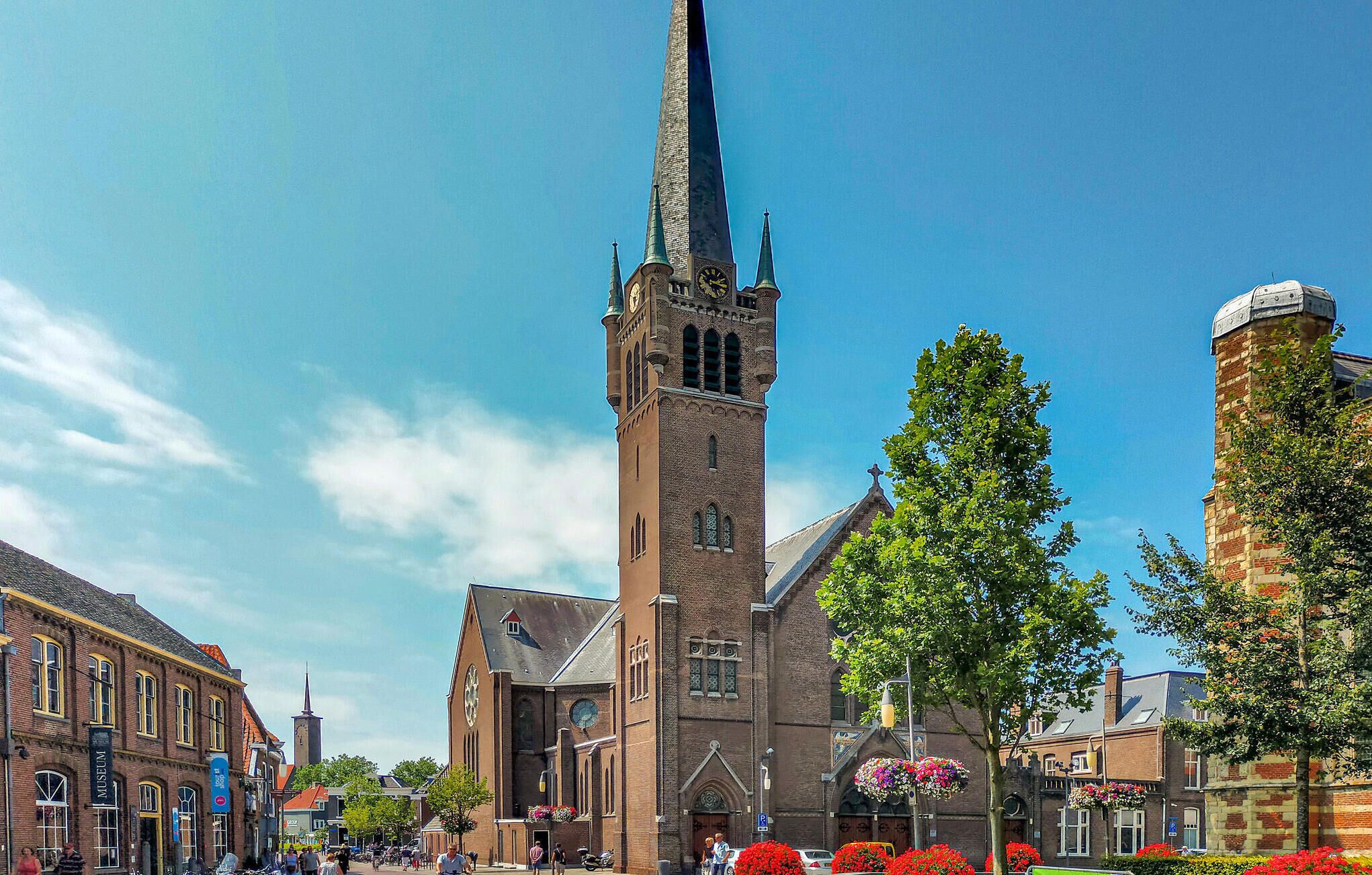A historic church with a tall spire, a clock tower, and a traditional brick facade.