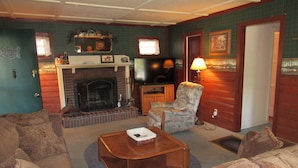 Una sala de estar acogedora con chimenea, televisor y asientos cómodos.