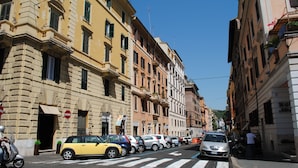 A street lined with multi-story buildings, parked cars, and a pedestrian crossing. - Apt next the Vatican both museum entrance\St Peter's basilica, Metro, a.c., wifi (Roma)