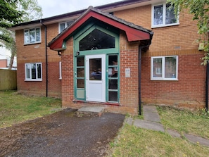 A brick building with a green door and windows.