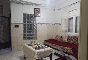 Traditional room with a sofa, table, and framed art, offering a comfortable space to work and relax.