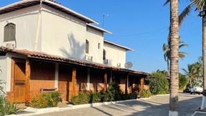 Un edificio a due piani con tetto in tegole, un portico coperto e un'antenna parabolica.