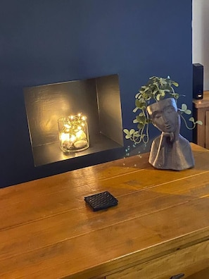 A wooden table with a glass jar of candles, a small plant, and a wallet. - Worthing Beach 180 - 2 bed Seafront With Parking (Worthing)
