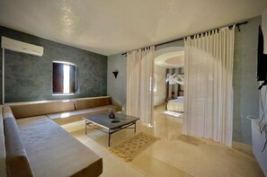 Relax in a spacious living area with a comfortable sofa, coffee table, and large window offering a view.