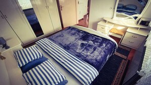 A bedroom with a bed, striped pillows, a nightstand, a dresser, and a mirror. - Beautiful 1-bed Apartment in Sveta Nedelja (Sveta Nedelja)
