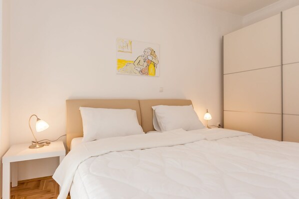 A bedroom with a bed, two bedside tables, and a wall-mounted artwork. - Modern accommodation with air conditioning, WiFi on the island of Krk (Baska)