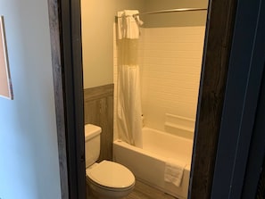 Ein Badezimmer mit Toilette, Badewanne und Duschvorhang.